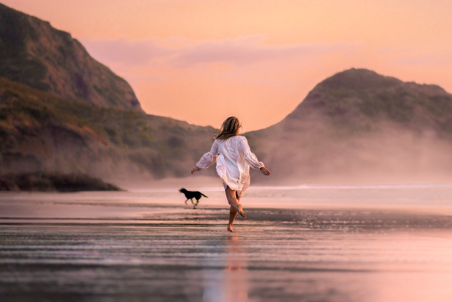 Urlaub mit dem Hund am Strand beim Sonnenuntergang