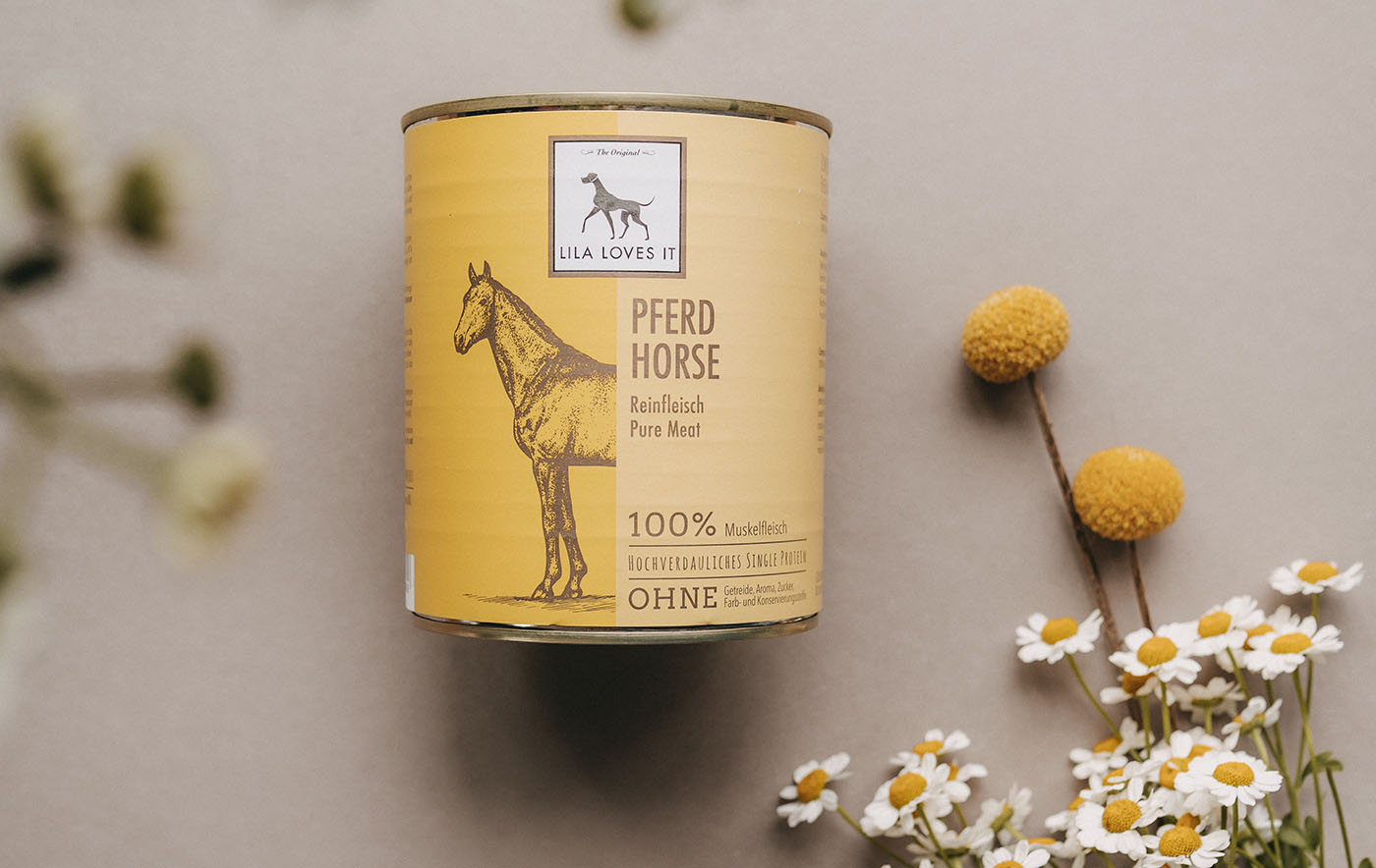 Große gelbe Dose Pferdefleisch für Hunde auf beigem Hintergrund mit einem Strauß Gänseblümchen | LILA LOVES IT "Nassfutter Pferd"